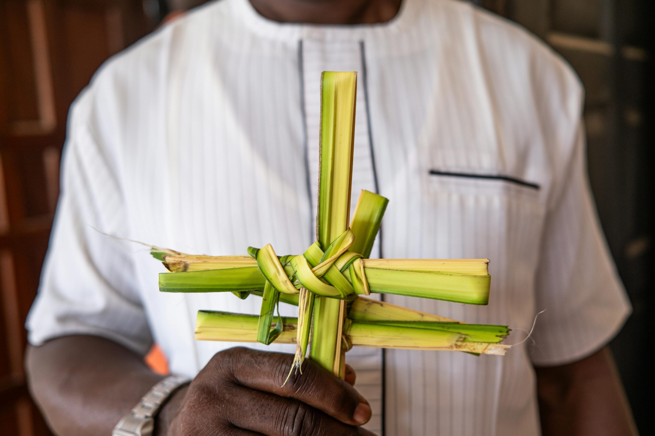 Adult man holding a traditional palm cross, symbolizing Palm Sunday in Benin City, Nigeria.